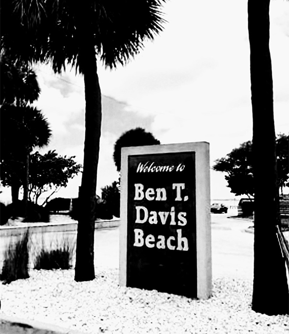Welcome to Ben T. Davis Beach sign surrounded by palm trees