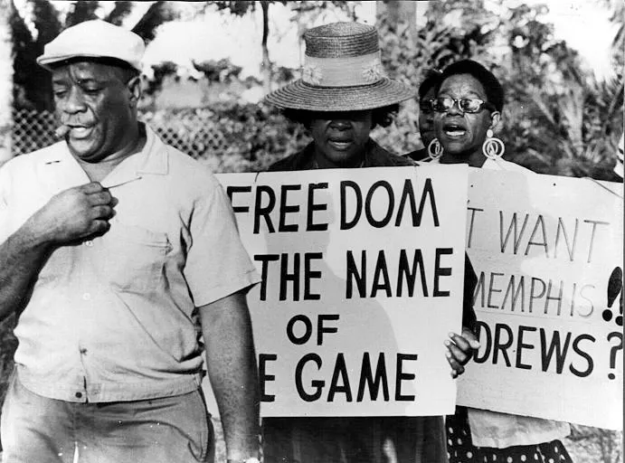 Civil rights protesters holding signs reading Freedom is the Name of the Game and I Want Memphis Andrews