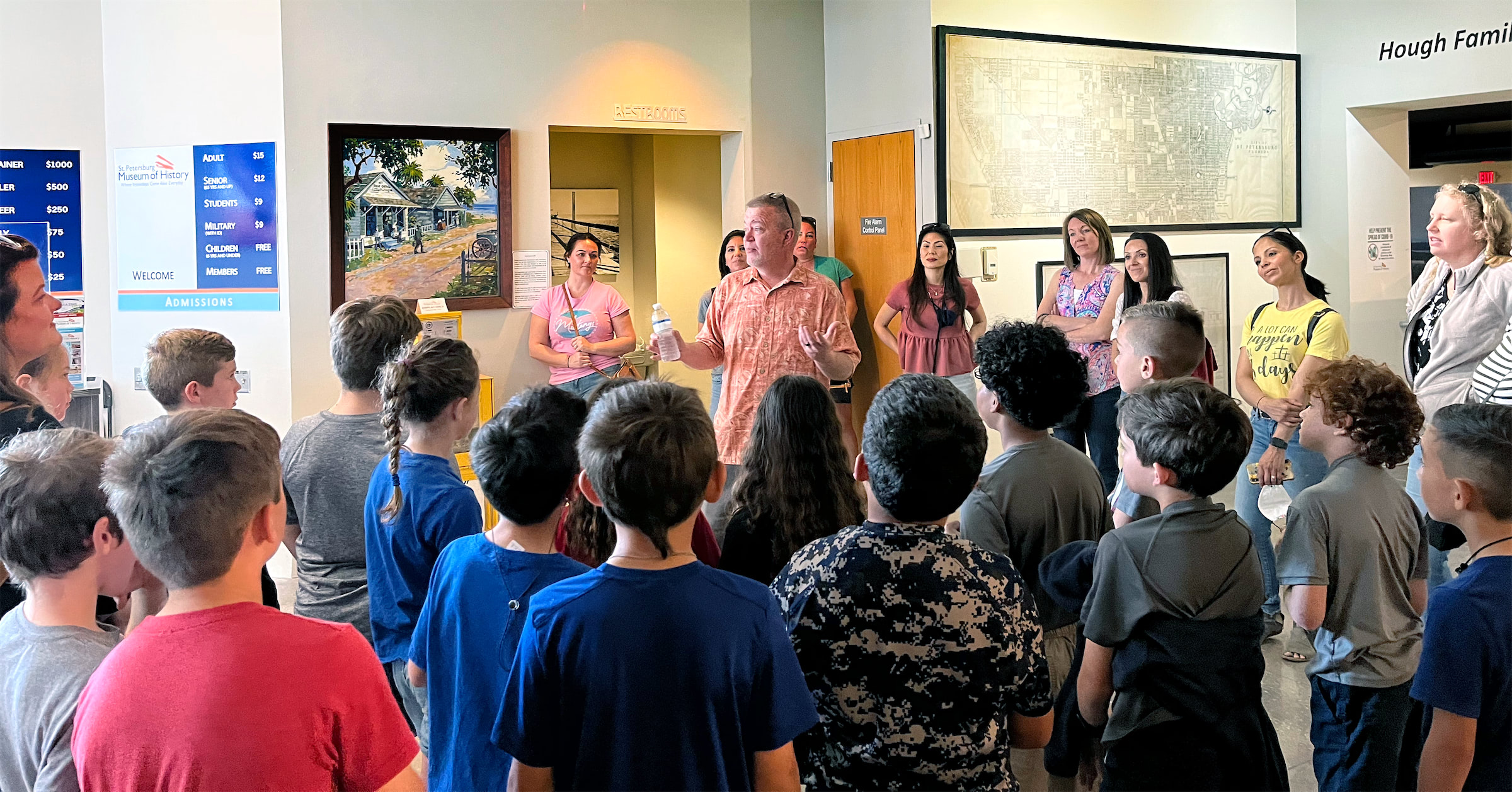 A guide addresses a group of students and chaperones in the lobby of the St. Petersburg Museum of History