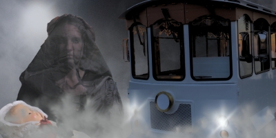 Ghostly figure draped in dark cloak beside a foggy trolley, with eerie faces emerging from the mist