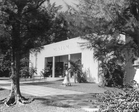 Black-and-white photo of a museum building exterior with a sign reading 