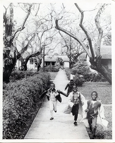 Children running and smiling, black-and-white photo
