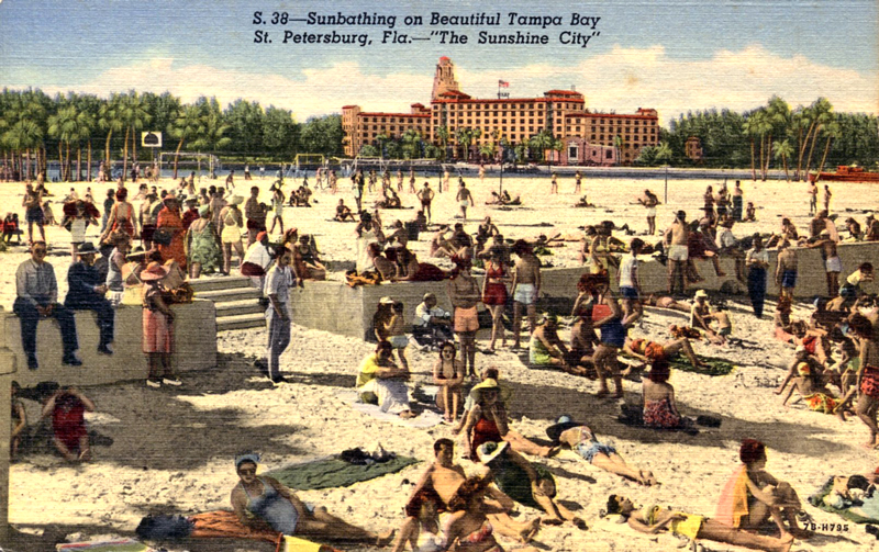 Vintage postcard of a crowded Tampa Bay beach in St. Petersburg, Florida, captioned Sunbathing on Beautiful Tampa Bay — The Sunshine City