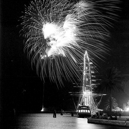 The Bounty, a replica ship constructed for a film, sits in St. Petersburg's Vinoy Basin at night with fireworks exploding in the background