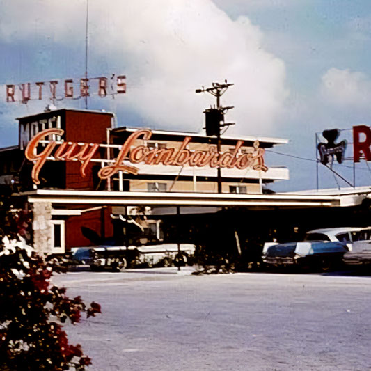 Guy Lombardo's Port-O-Call is a modern (for the time) building with neon signage and cars of the same era parked in the parking lot out front.