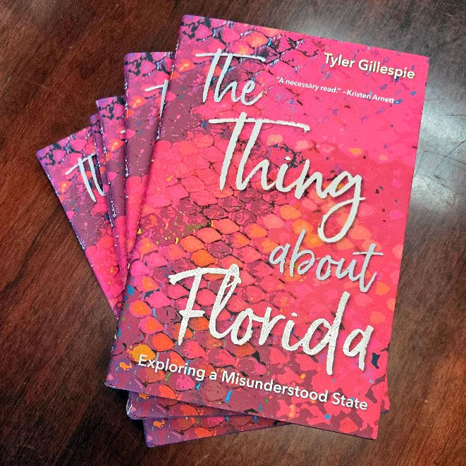 Stack of books on a wood table, books are titled "The Thing About Florida"