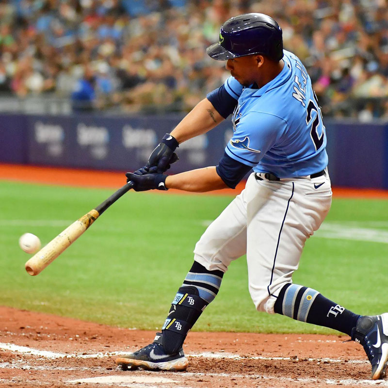 Tampa Bay Rays player Francisco Mejía swinging a bat as it is about to contact with a baseball
