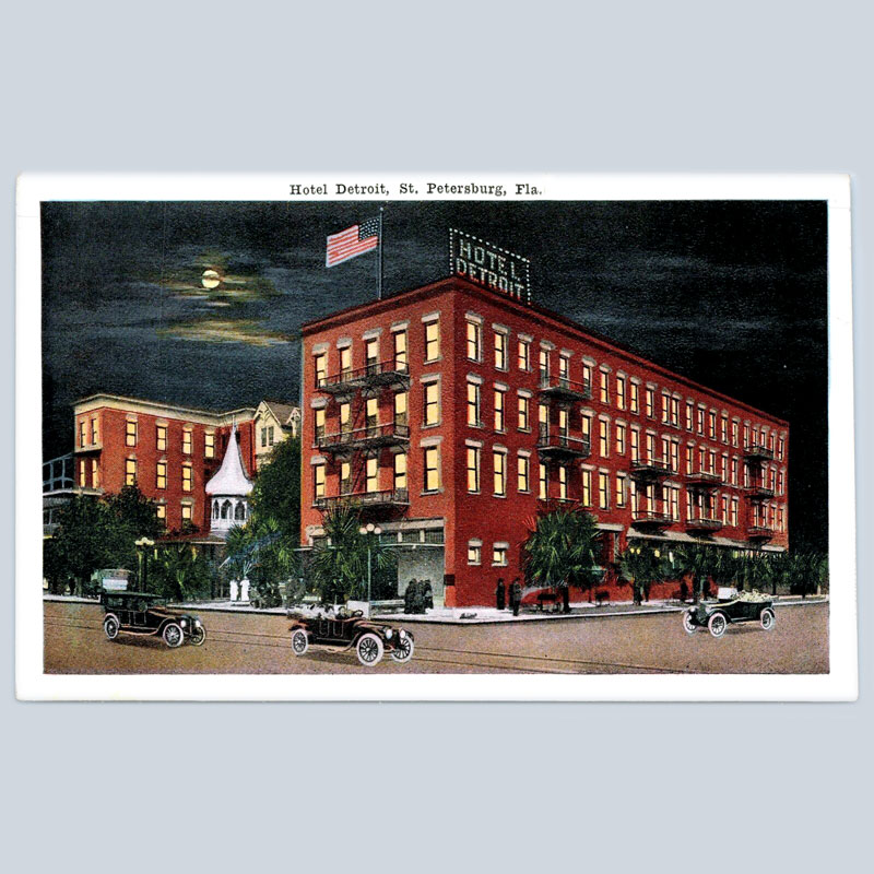 A brick hotel building on a postcard at night
