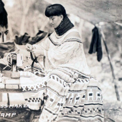 A seminole woman sews a clothing garment