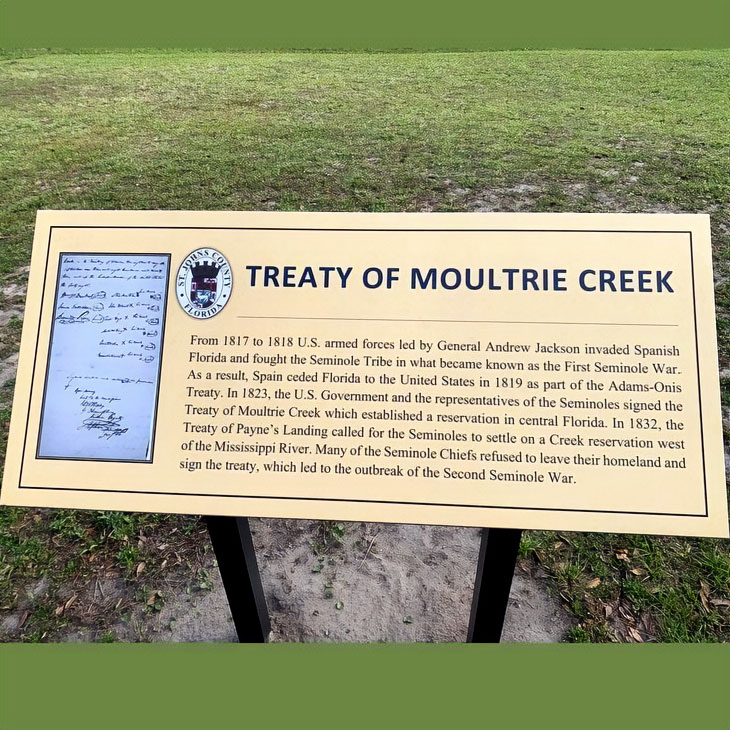 A historic marker sign detailing the Treaty of Moultrie Creek with very small type
