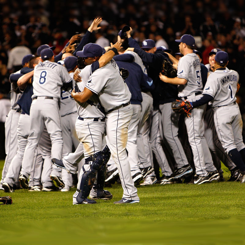 Tampa Bay Rays players in group hug on the field after a major victory