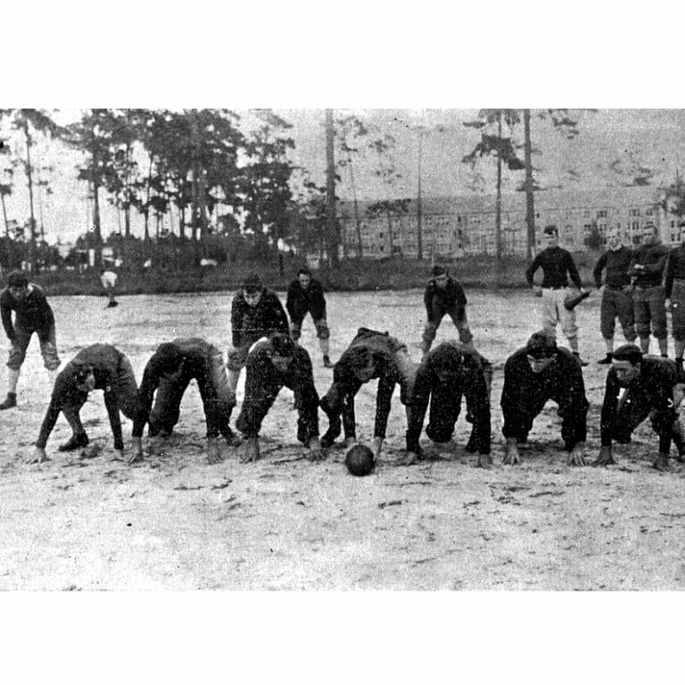 Black and white photo of football players crouched down ready to make a play