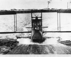 Benoist airplane as it reaches the ramp, c. 1914. The ice plant and electric plant smokestacks are in the background. Benoist airplane as it reaches the ramp, c. 1914. The ice plant and electric plant smokestacks are in the background.
