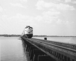 Seaboard Coast Line train, a diesel engine, on the Cross Bayou trestle at Bay Pines. c. 1965