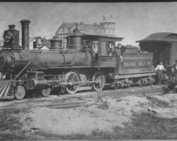 Orange Belt Railroad engine No. 7, tender, and baggage car. Detroit Hotel and other buildings on Central Ave. in background. Probably 1890. RA dates 1893; RWA dates 1890 and refers to train as 'Shoo-Fly Special.'. Orange Belt Railroad engine No. 7, tender, and baggage car. Detroit Hotel and other buildings on Central Ave. in background. Probably 1890. RA dates 1893; RWA dates 1890 and refers to train as 'Shoo-Fly Special.'.