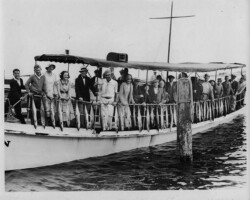 Party boat with people showing off their fish catches. c. 1935