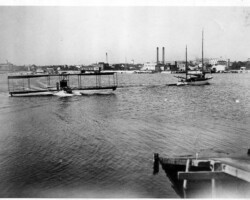 Benoist No. 45, the FLORIDA, crashed by Tony Jannus in Feb 1915, later rebuilt, on water approaching ramp on the north mole. Prominent buildings in background are the power plant (four stacks), ice plant, Tomlinson tower, and West Coast Inn. Benoist No. 45, the FLORIDA, crashed by Tony Jannus in Feb 1915, later rebuilt, on water approaching ramp on the north mole. Prominent buildings in background are the power plant (four stacks), ice plant, Tomlinson tower, and West Coast Inn.