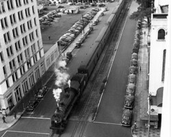 ACL train passing down 1st Ave S, crossing 5th St S. Webb's City far background. c. 1948