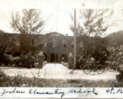 Historic black-and-white photo of Jordan Elementary School in St. Petersburg, Florida, with trees and a bicycle visible outside
